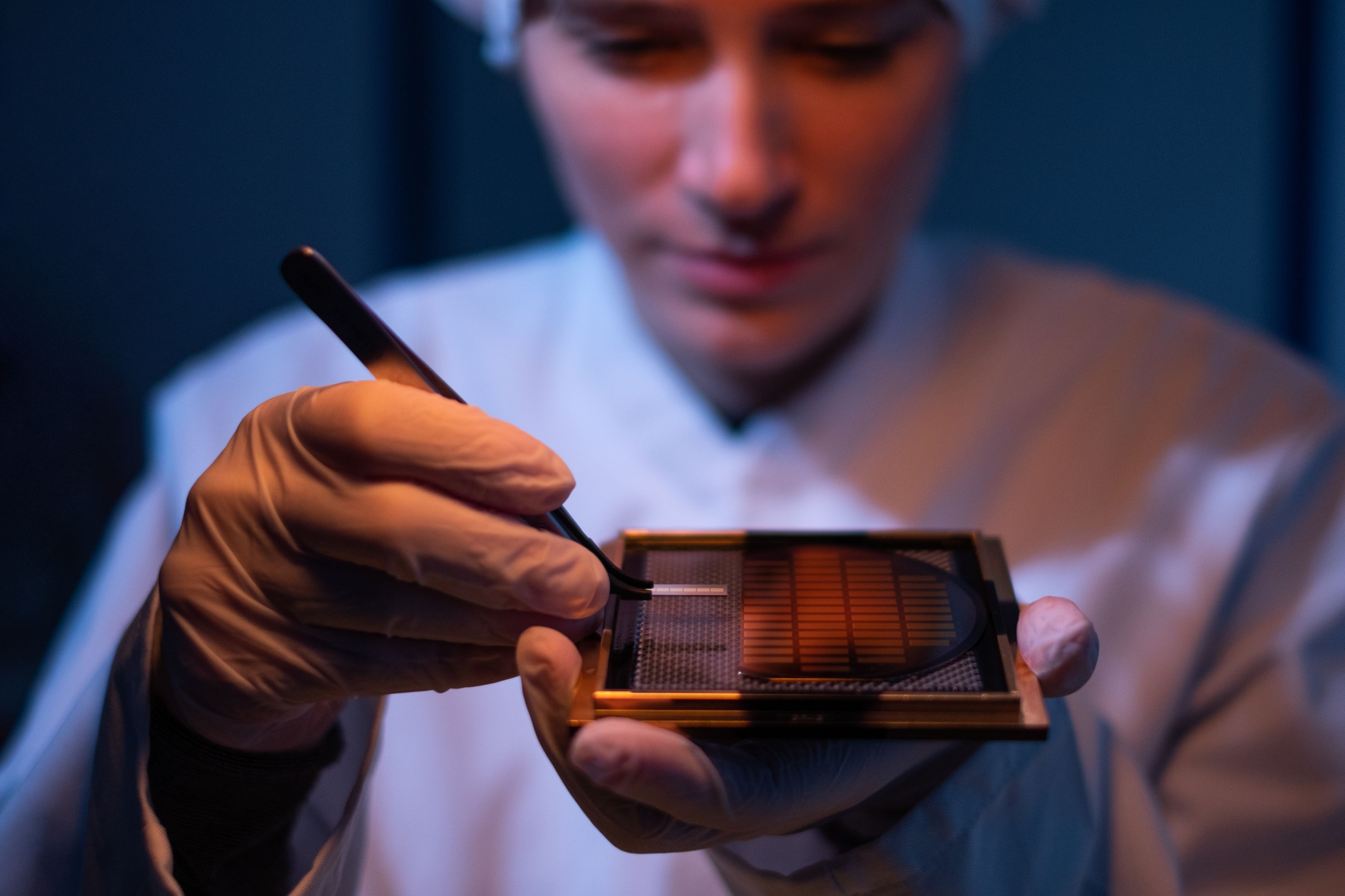 A Q.ANT employee examines the quantum chip