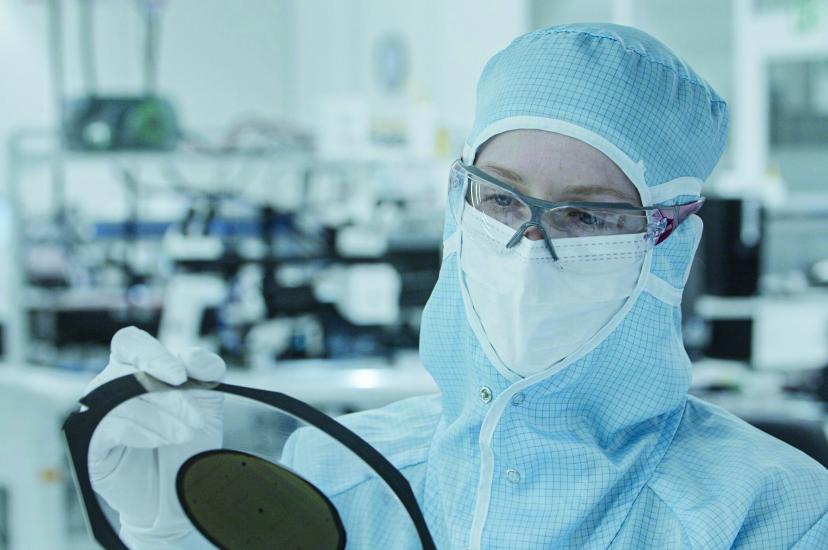 Worker inspecting semiconductor wafer