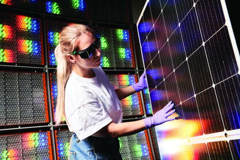 A woman inspecting a photovoltaic solar panel