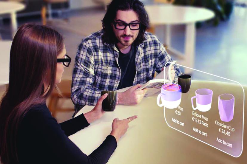 A man and a woman sit in front of an augmented reality screen
