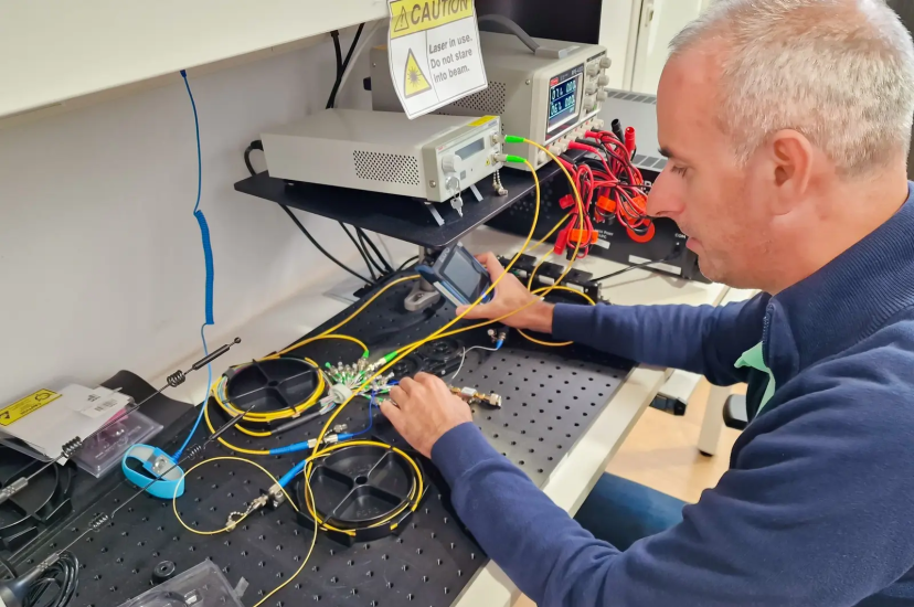 A man sits at a lab bench connecting wires