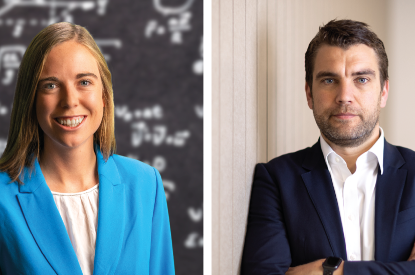 A woman with blonde hair weairng a blue suit stands in front of a blackboard of equations on the left, and right, a dark-haired man wearing a suit stands, arms folded, in front of a beige background
