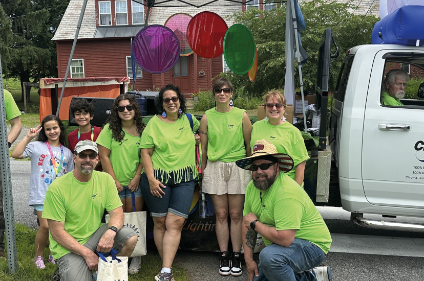 Chroma employees wearing green shirts under a gazebo with a truck in the background