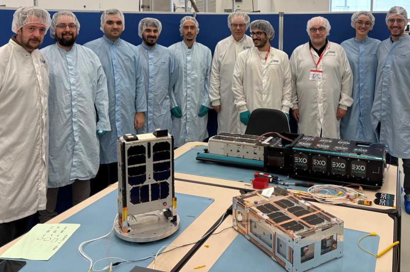 Development team surrounding satellites in testing