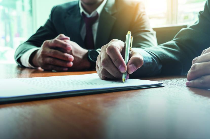 Signing a contract with a pen on a desk