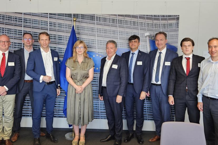 A woman flanked by seven men with a European flag in the background