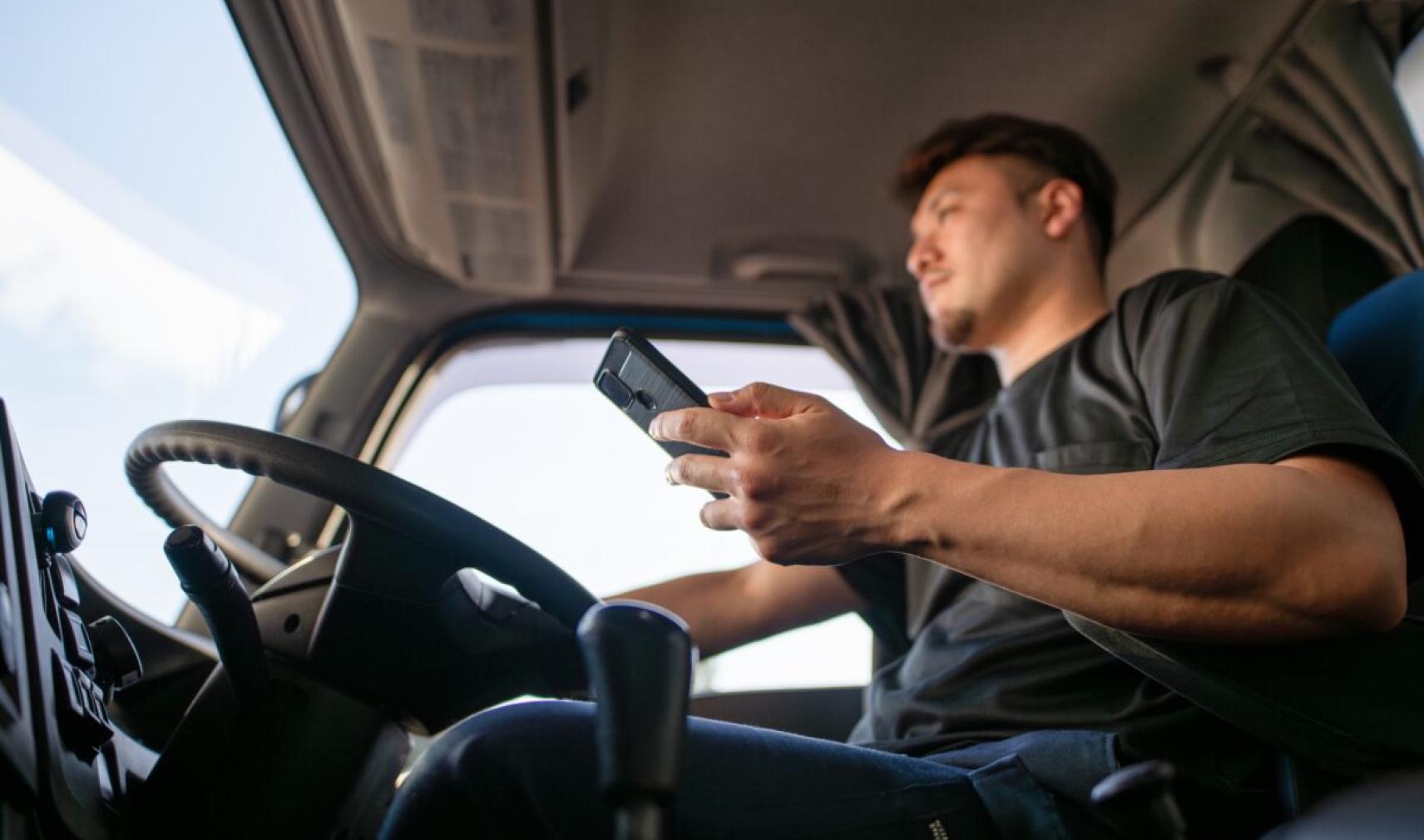 Truck driver driving while using phone