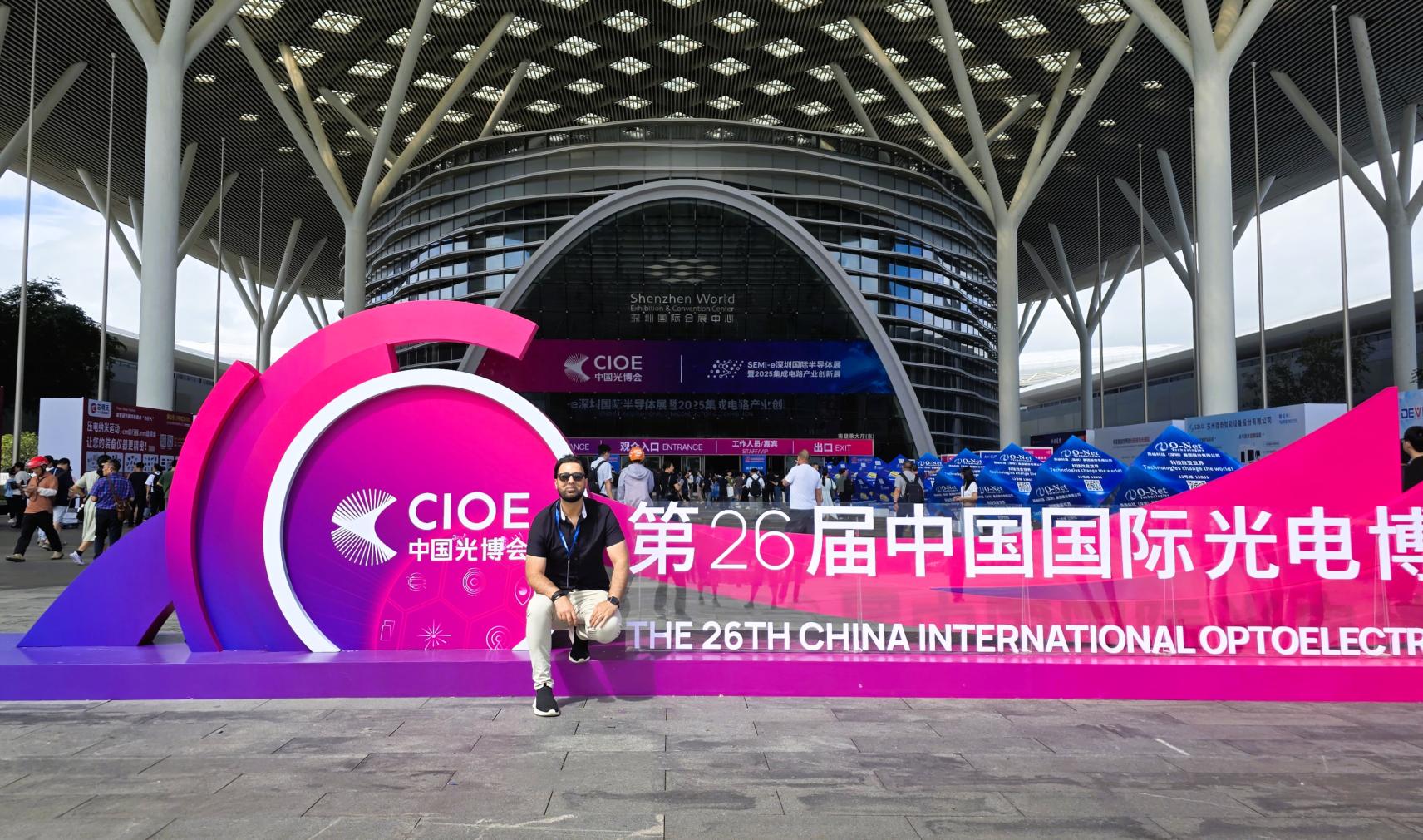 Dr Faisal Kamran sits on a sign outside the CIOE exhibition in Shenzhen, China