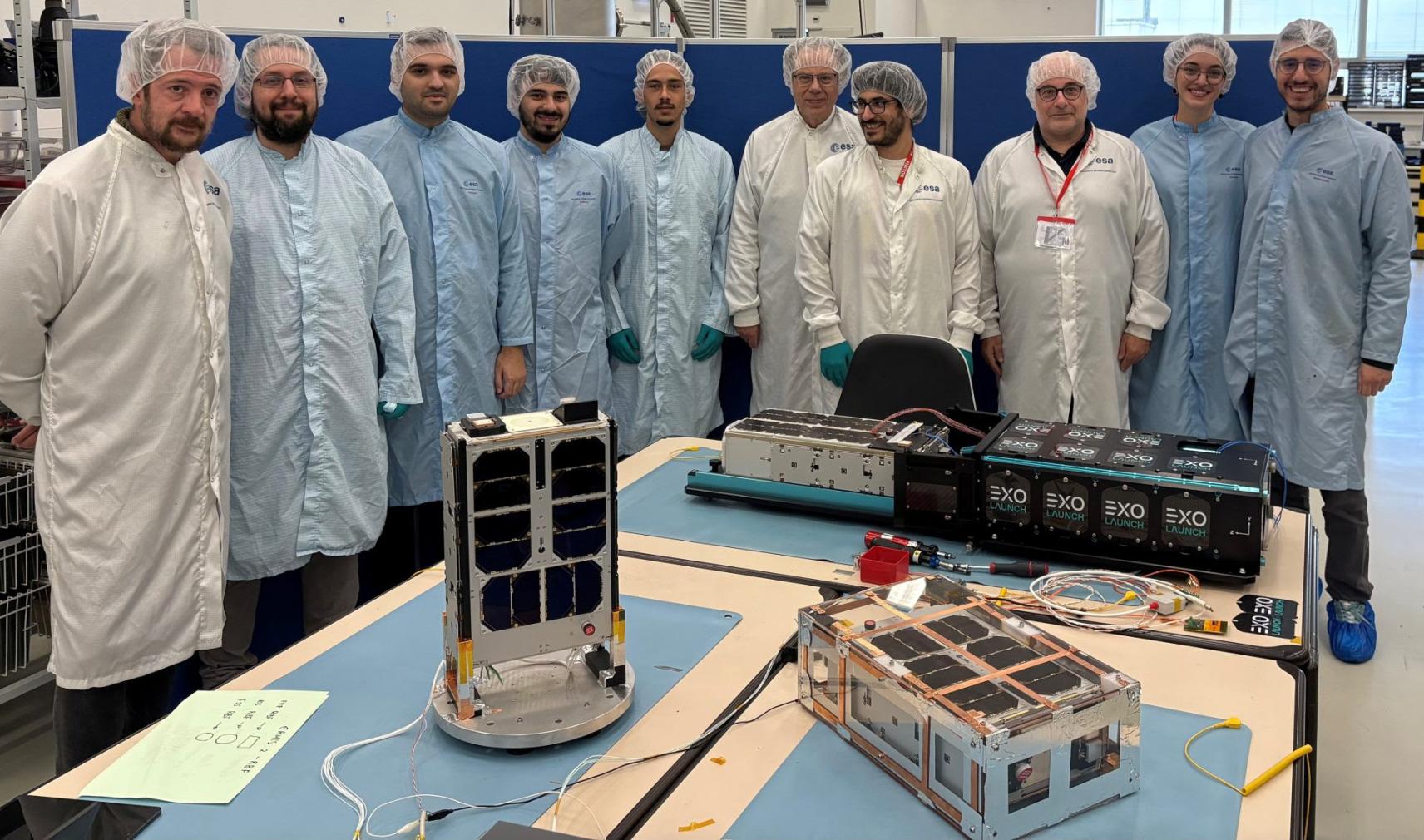 Development team surrounding satellites in testing