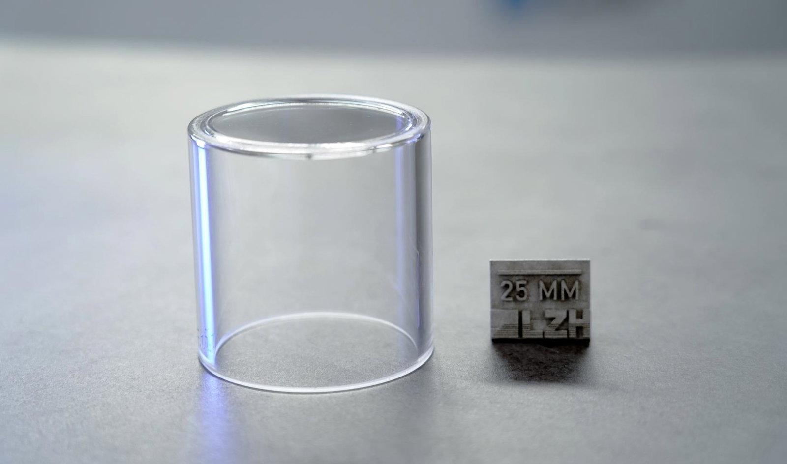 Thick-walled glass container next to 25mm measurement