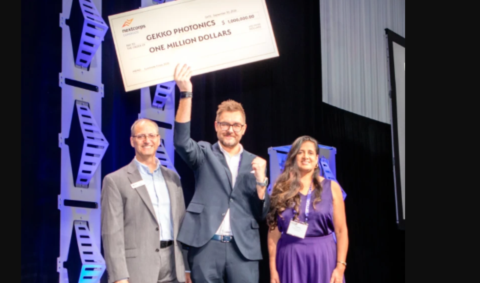 Gekko Photonics wins Luminate NY holds cheque aloft on stage
