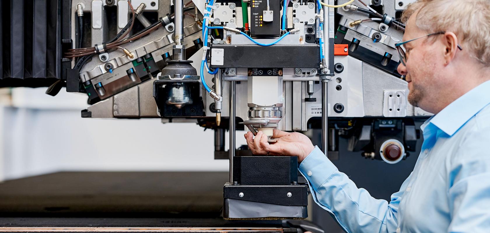 A worker adjusts the Trump TruMatic 5000 punch paser machine