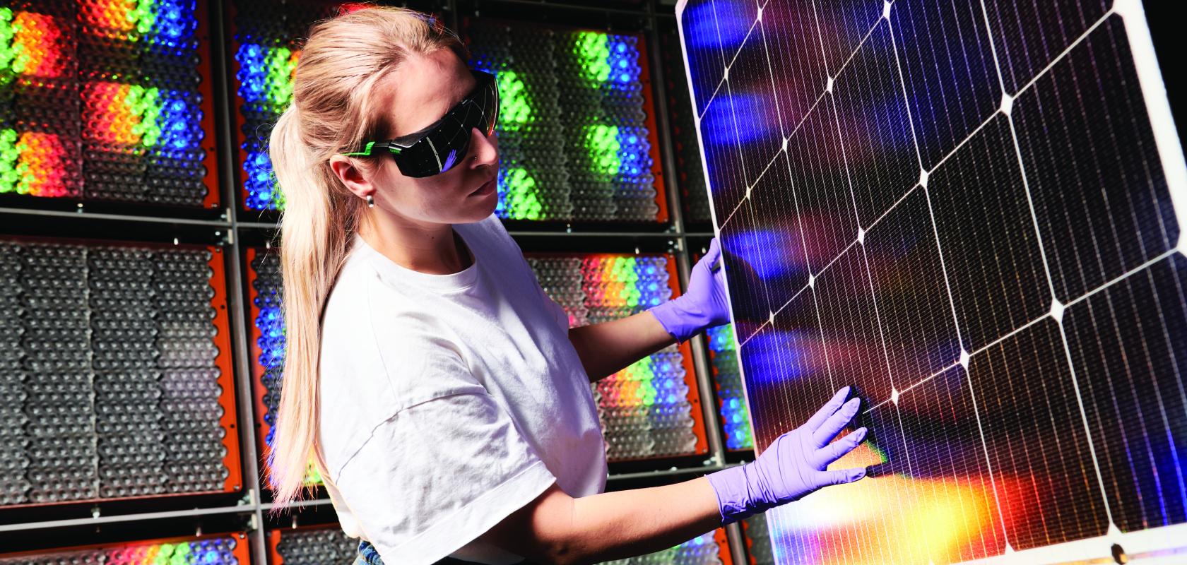 A woman inspecting a photovoltaic solar panel
