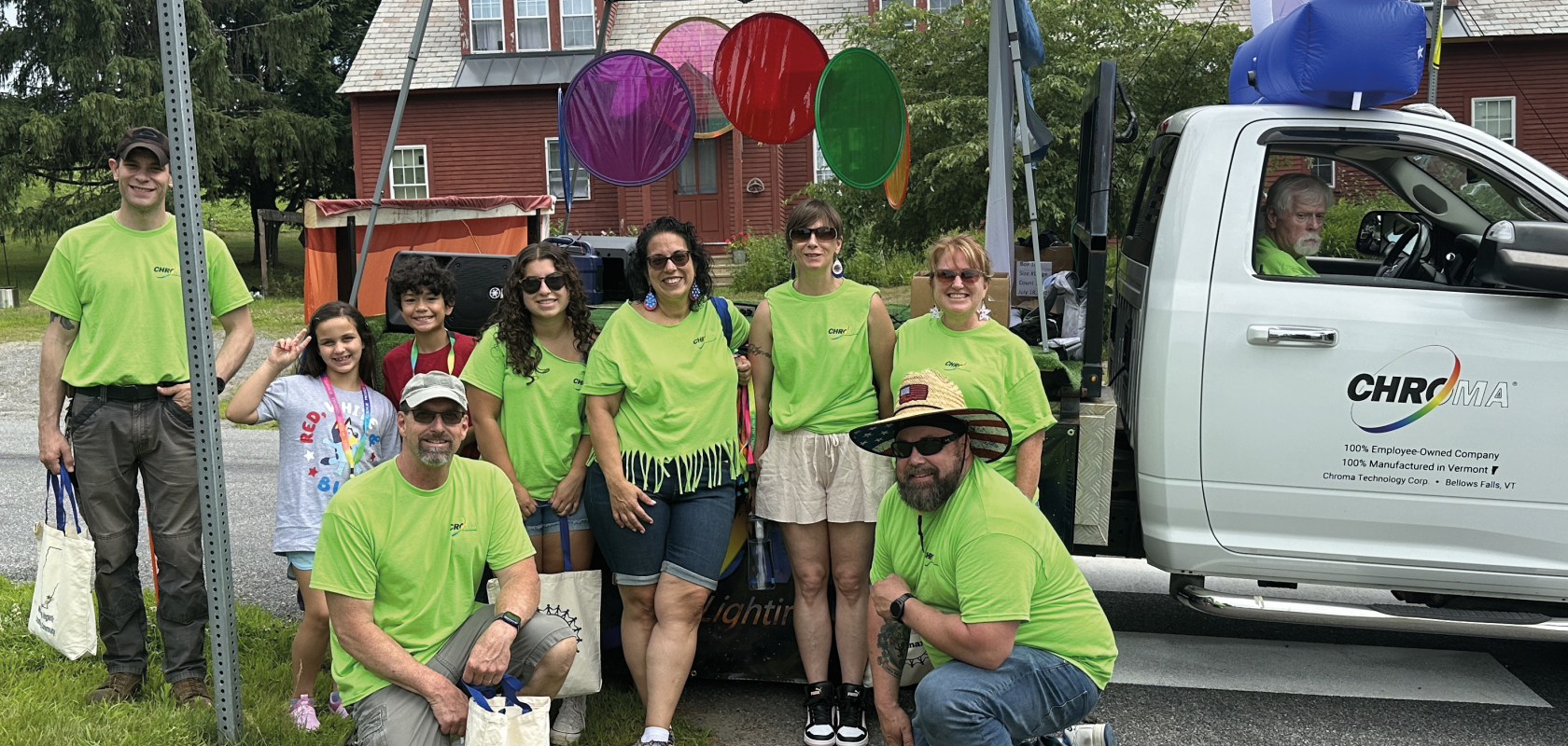 Chroma employees wearing green shirts under a gazebo with a truck in the background