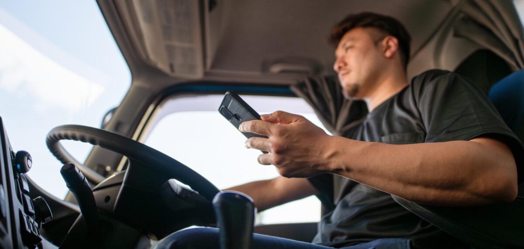Truck driver driving while using phone