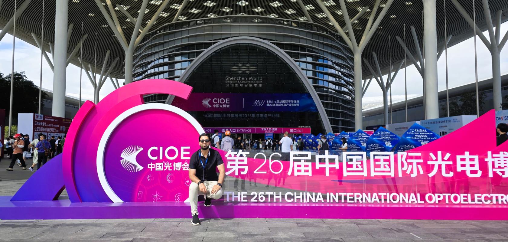 Dr Faisal Kamran sits on a sign outside the CIOE exhibition in Shenzhen, China