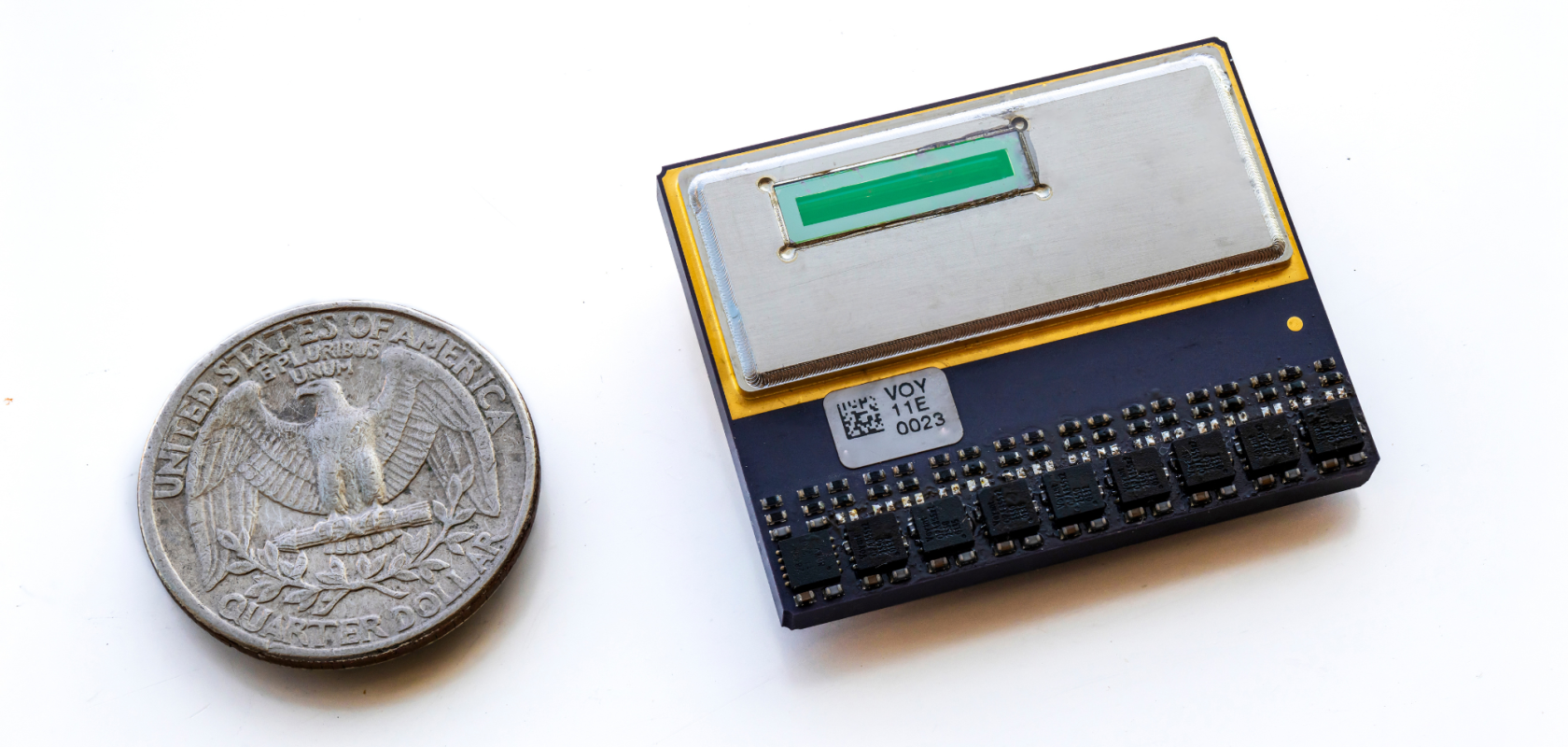 A small integrated circuit next to a quarter