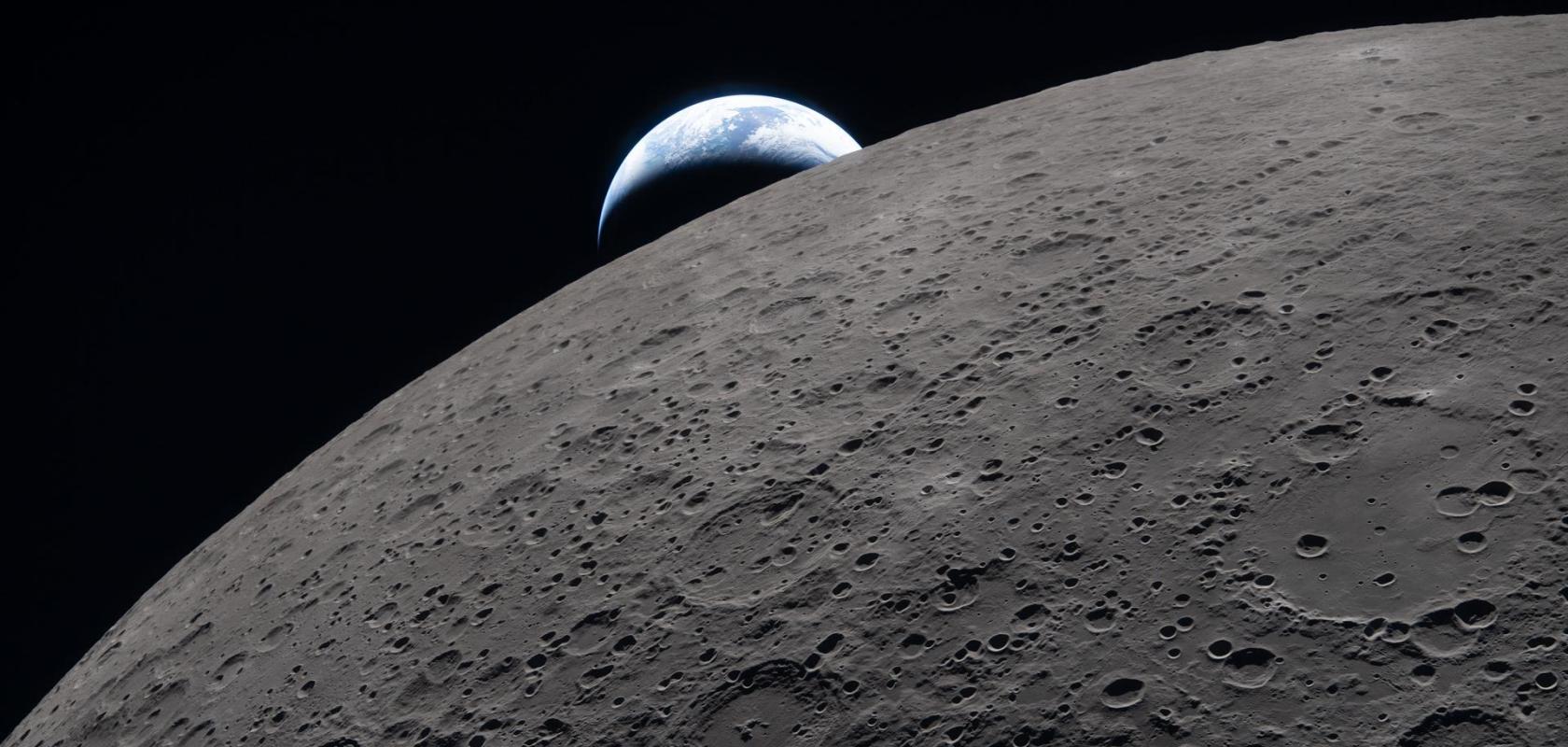 Lunar surface with a distant Earthset in the background