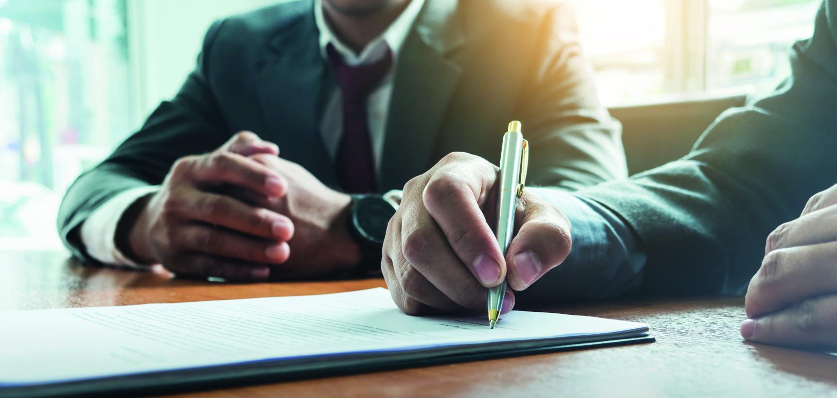 Signing a contract with a pen on a desk