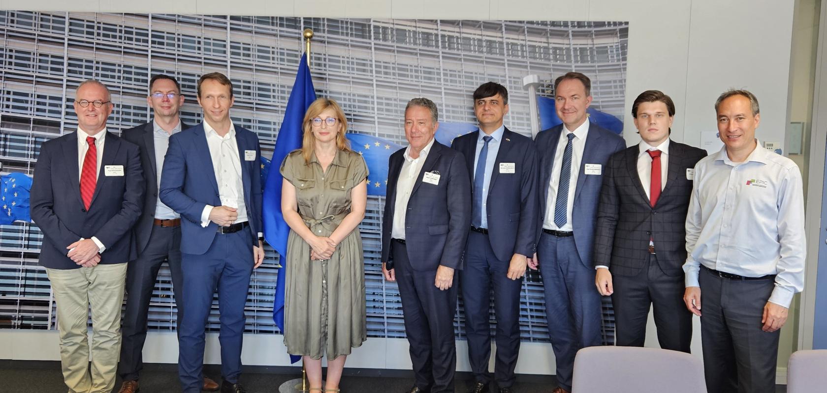 A woman flanked by seven men with a European flag in the background