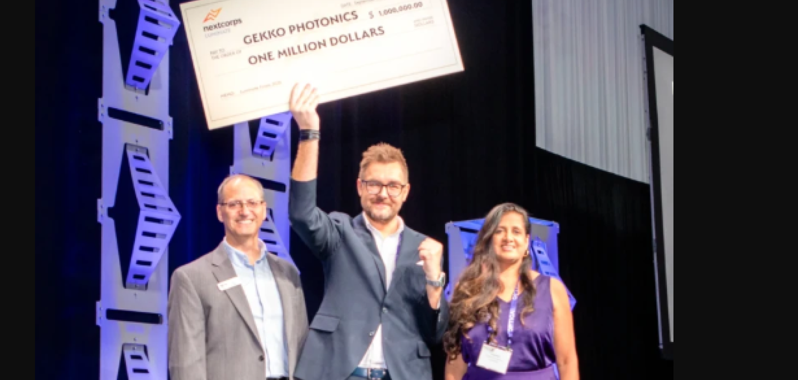 Gekko Photonics wins Luminate NY holds cheque aloft on stage