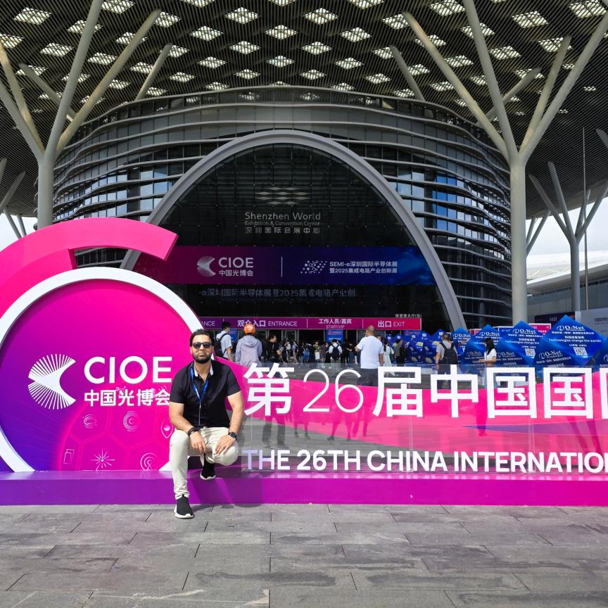 Dr Faisal Kamran sits on a sign outside the CIOE exhibition in Shenzhen, China