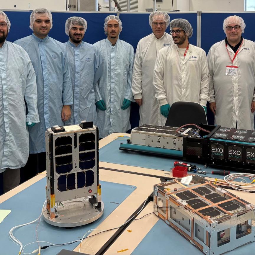 Development team surrounding satellites in testing