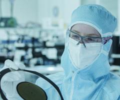 Worker inspecting semiconductor wafer